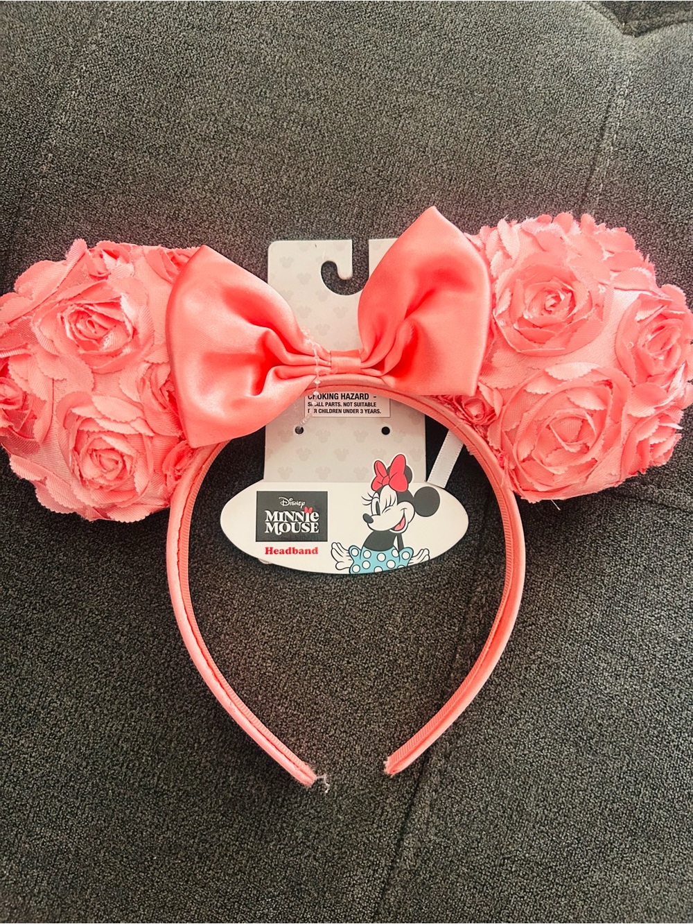 pink Disney Minnie Mouse ears feature satin roses and a matching satin bow